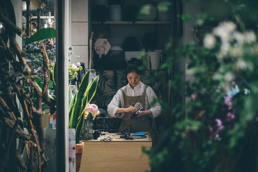 Fleuriste dans sa boutique entourée de compositions florales